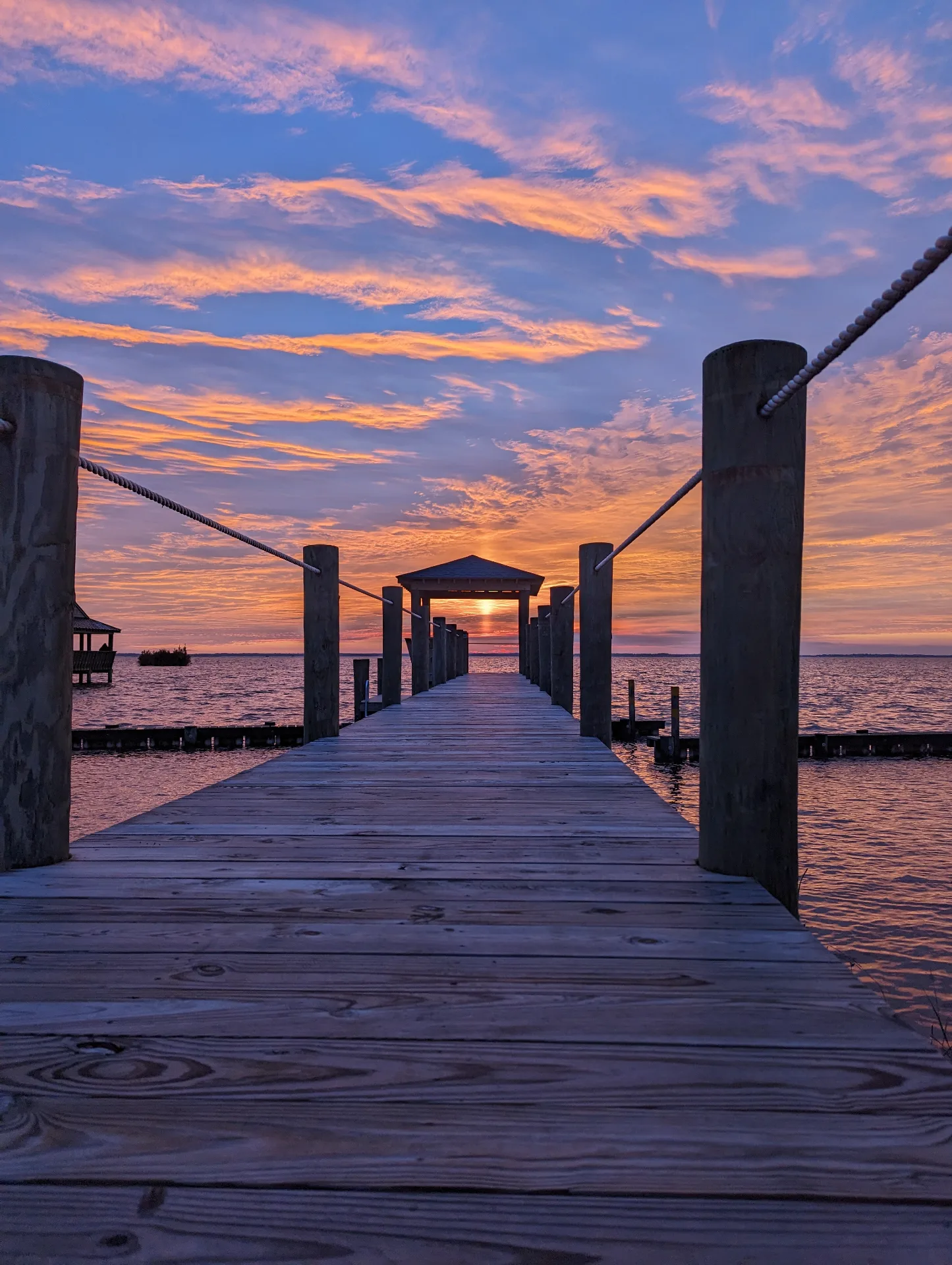 Private dock with golden sunset on Currituck Sound at Hygge on the Bay Outer Banks
